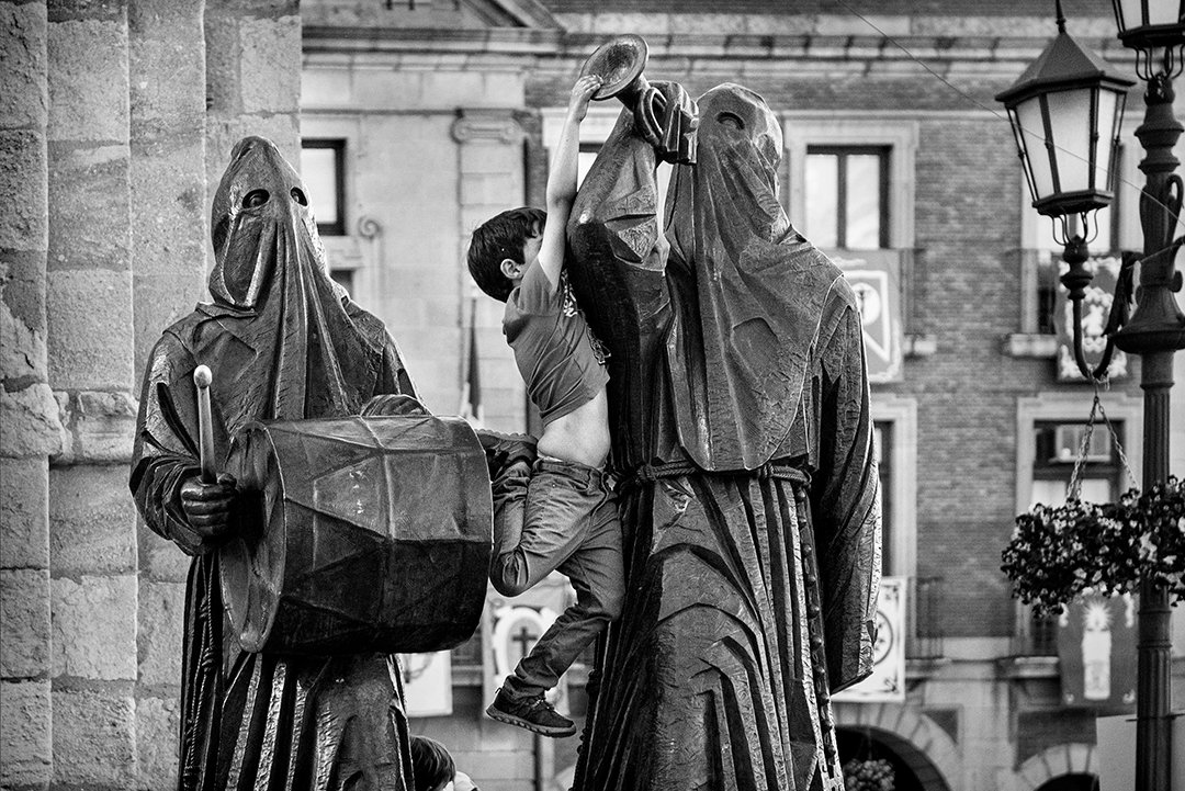 Religious statues covered with plastic on a street.